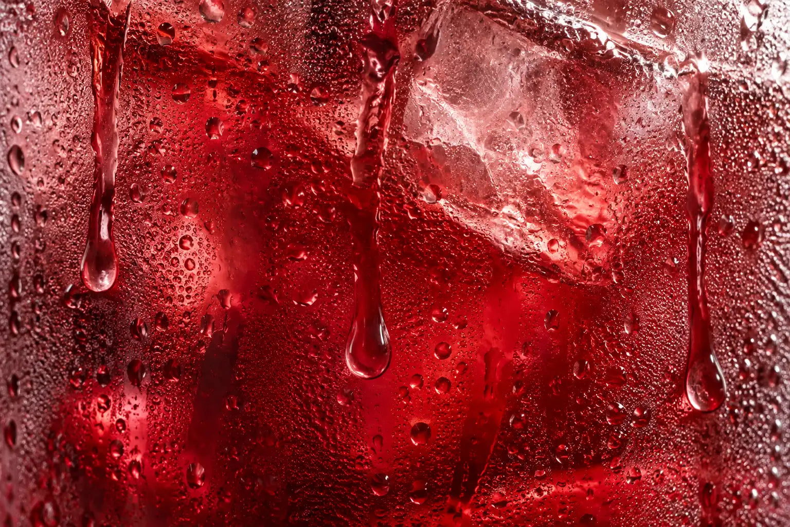 Macro ilustrativa: gotas de condensação num copo gelado de chá de hibisco